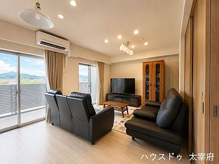 大きな窓から自然光がたっぷりと入り、明るく爽やかな雰囲気が広がっています。緑豊かな山並みや空が望め、開放感のある景色を楽しめます。※AIによる画像加工を行っています。現況を優先いたします。