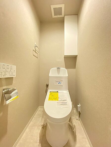 明るい色合いでまとめられた清潔感のあるトイレ空間です。上部の収納棚には、トイレットペーパーなどをすっきりと収納できます。