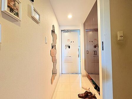 【玄関】家族やゲストをスマートに迎え入れる、清潔感あふれるクリーンな玄関アプローチ。洗練された空間設計が、都会の利便性を享受しながら私空間へと戻る安心感を確実に創出。※CGで家具消し加工
