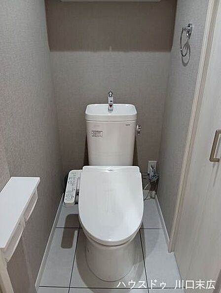 いつでも快適に使用できる温水洗浄便座付きのトイレ。上部には小物を置ける棚を設け、清潔感のある空間に仕上がっています。