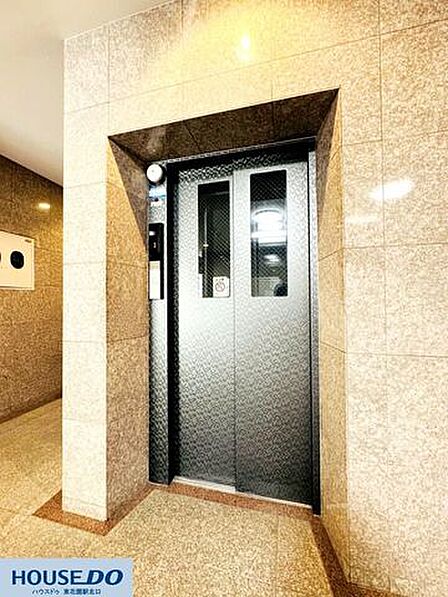 重厚な石目調のタイルに包まれたエレベーターホール☆ガラス越しの光と間接照明が、落ち着いた雰囲気を演出♪お出かけも帰宅も、優雅な気分で過ごせそうですね！
