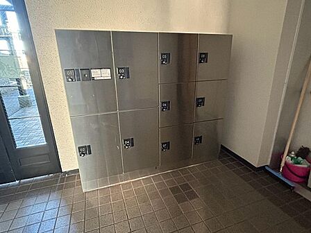 共用エントランスに設置した宅配ボックス。不在時にも荷物を受け取れ、外出や仕事で留守にする日も便利です。サイズの異なる収納区画を備え、日々の受け取りをサポート。利用方法や荷物の対応サイズも確認できます。