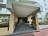 エントランス：屋根のあるエントランスが、毎日の帰宅を迎えてくれます。階段には手すりがあり、脇にはスロープも設けられています。植栽に囲まれた落ち着いた入口。共用部分の様子も、ご見学の際に現地で直接ご確認いただけます。
