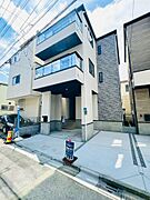 スタイリッシュなデザインが印象的な外観。モダンなフォルムと落ち着いた色合いが調和し、洗練された住まいを演出しています。駐車スペースも確保されており、利便性とデザイン性を兼ね備えた邸宅です。