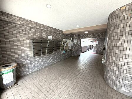 住宅街の雰囲気に馴染むタイルで装飾されており、実用性と安心感を重視したシックなエントランス構造です。