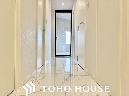 玄関を開けると、明るい日が差し込むリビングへと誘う廊下。