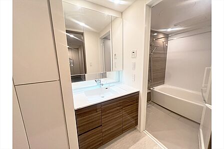 洗面室には収納もあり、タオルや掃除用具などをしまっておくのに大変便利です。白と茶色を基調とした統一感ある内装です。