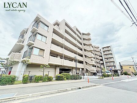 オークリッチむこうまち。前面道路がすっきりと整備され、見通しの良いアプローチが特徴の外観。小さなお子様連れでの移動や、ベビーカー、毎日のお買い物帰りでもスムーズに移動ができて便利です。