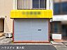外観：店舗正面を大きく捉えた写真。鮮やかな黄色のテントが目を引く、視認性の高い外観です。
