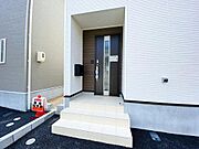 明るい外観に引き締めカラーになるブラウンの玄関扉がおしゃれです