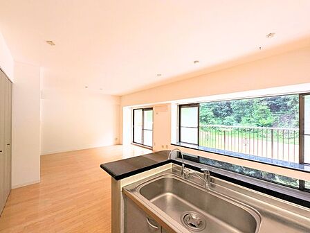 キッチンからリビング全体と外の緑が見渡せる設計。お料理中も開放的な気分を味わえます。