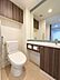 その他：大きな鏡と手洗いカウンターを備えた、ホテルライクなトイレ空間。吊戸棚や収納スペースもあります。