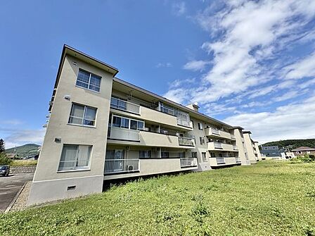 1階の専用庭が広がる、日当たりの良い外観。駐車場も近く便利です。小学校徒歩6分、中学校徒歩3分。