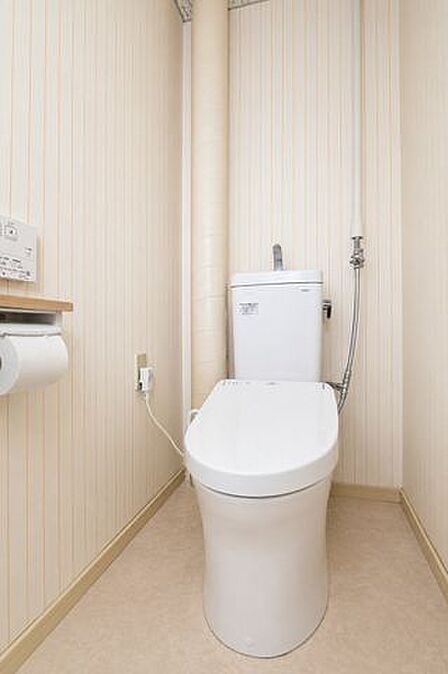 温水洗浄便座付きで快適。ストライプ調の壁紙が爽やかなトイレ。※現地の撮影写真を基にCG加工編集済