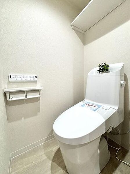 【トイレ】上部に備え付けの収納棚を配置。トイレットペーパーや掃除用品を整理して収納可能です。