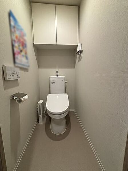 【トイレ】温水洗浄便座+手洗い器付き。背面上部に吊戸棚があり、トイレットペーパーなどのストックが可能です。