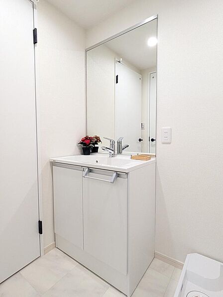 一日のはじまりと終わりを彩るパウダールーム。シャワー付きの洗面化粧台は朝の準備に便利です。タオルを置ける棚もあるので、スッキリ使っていただけます。