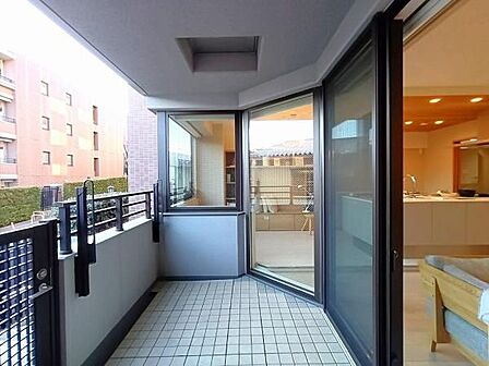 リビングからフラットに続くような配置で、大きなガラス戸を通じて室内と外が一体化しているバルコニー。床面がタイル貼りになっており、見た目がスタイリッシュな仕様です。
