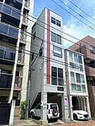 コンクリート打ち放しのような質感のグレーの外壁に、赤い縦ラインがアクセントとなっており、都会的で洗練された印象を与えています。3路線利用可能の利便性良好な立地です。