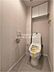 トイレ：毎日使う場所だからこそ嬉しい、温水洗浄便座付きの快適なトイレ空間です。落ち着いた色合いのクロスが採用されており、シンプルながらも洗練されたモダンな雰囲気を演出しています。