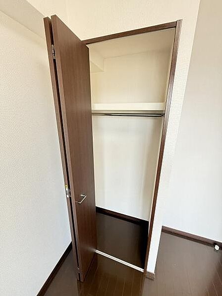 クローゼットにはハンガーパイプが設置されており衣類や小物を整理しやすい仕様です。扉が大きく開くため出し入れもスムーズに行えます。奥行きも十分に確保されているので収納スペースとして便利に活用できます。