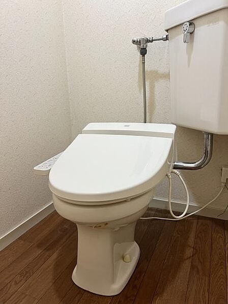 【トイレ】温水洗浄便座付きのトイレ。落ち着いた色調で清潔感のある空間です。