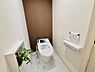 トイレ：落ち着きのあるアクセントクロスが特徴的なトイレです。手元に便利なペーパーホルダーや操作パネルが設置されています。観葉植物が空間を爽やかに演出しています。ゆったりとしたスペース設計です。