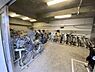 その他：屋内に設置された自転車置き場です。ラックがあり多くの自転車を収容できるスペースが確保されています。雨風から自転車を守れる点が特徴です。出入り口が広くアクセスしやすい環境です。