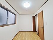 明るい照明がしっかりと設置されており室内全体が見やすい印象です。大きな窓から自然光も取り入れられます。シンプルな内装で使い勝手の良い洋室です。床や建具の色合いが落ち着いており清潔感があります。