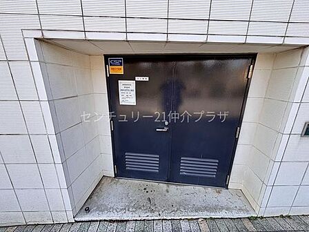 建物の外壁と一体感のある扉が設置されています。しっかりとした造りで安心感があります。シンプルなデザインが特徴的です。両開き扉で大きな荷物の搬入にも対応できます。