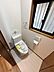 トイレ：明るい空間に設置されたトイレです。窓からの採光があり清潔感が感じられます。シンプルなデザインで使いやすさが意識されています。ペーパーホルダーやリモコンが壁付けで空間を広く利用できます。