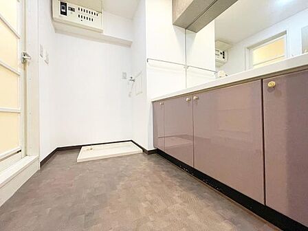 落ち着いたカラーの床と収納が特徴的な洋室です。シンプルな内装で多様なアレンジが楽しめます。天井までの高さが開放感を演出しています。室内は明るく清潔感があります。扉や設備も機能的に配置されています。