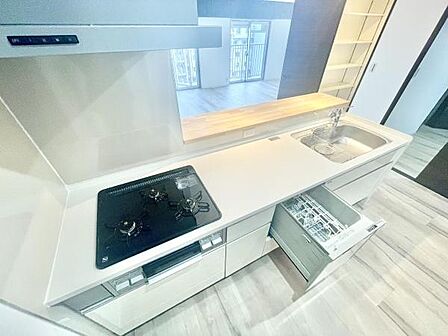 広々としたキッチンには使いやすいガスコンロと食洗機が設置されています。カウンター付きで開放感があります。収納スペースも豊富なので整理しやすいです。シンプルなデザインが空間に調和しています。