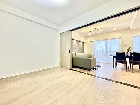 洋室は明るいフローリングが特徴で開放感のある空間です。引き戸を開放することでリビングと一体感を持たせることができます。室内はシンプルな仕上げでさまざまなインテリアにも対応しやすいです。