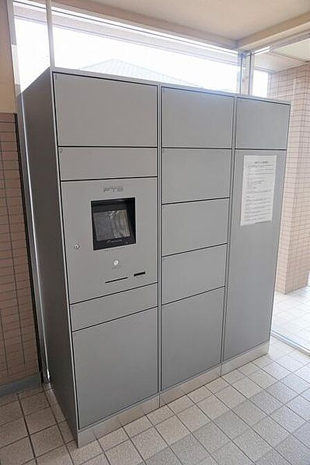 共用部に宅配ボックスが設置されています。荷物の受け取りがしやすく不在時でも安心です。シンプルなデザインで空間に調和しています。建物の利便性を高める設備です。