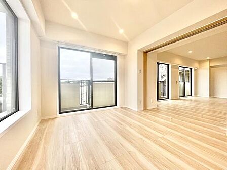 大きな窓からたっぷりと自然光が入り明るさが魅力の寝室です。木目調のフローリングが空間に温かみを与えています。バルコニーに面しており開放感のある設計です。清潔感のある内装が印象的です。