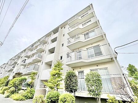 明るい外観が特徴の建物です。バルコニーが複数設けられており開放感があります。エントランス周辺には緑が植えられており景観も整っています。白を基調としたデザインで爽やかな印象を与えます。