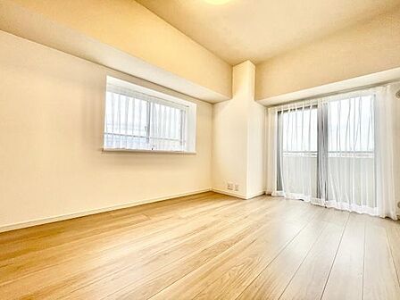 明るい光が差し込む洋室です。ナチュラルなフローリングが室内をすっきりと見せています。窓が2箇所あるため開放感があります。カーテンレール付きで使いやすい空間です。室内はシンプルなデザインです。