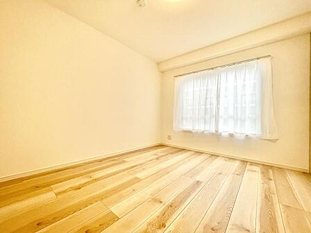 明るい光が差し込む寝室です。ナチュラルな木目の床が印象的な空間です。シンプルな内装でコーディネートがしやすいお部屋です。ゆったりとした広さが確保されています。窓からの採光で開放感も感じられます。