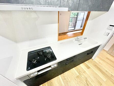 キッチンは白を基調としたシンプルなデザインで清潔感があります。ガスコンロが3口あり使い勝手が良好です。上部や下部の収納も充実しているので整理整頓がしやすい仕様です。
