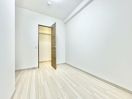 明るい色調の床材が印象的な洋室です。クローゼットが付いておりすっきりとした空間を実現しています。シンプルな内装で幅広いインテリアに対応できます。ドアもナチュラルな木目調で統一感があります。