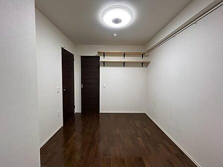 落ち着いた色味の建具に囲まれた洋室です。ドア一枚を隔てて個室として使えるため、家族それぞれのプライベートな時間を確保できます。窓辺の光も室内まで柔らかく届きます。