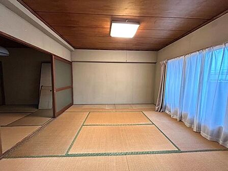 カーテン越しの光が入る和室は、正座をしても立っても心地よい高さの窓が印象的です。来客用の布団を敷く部屋としても活躍しそうです。