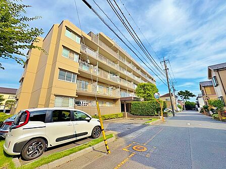 青空に映えるスタイリッシュな外観デザイン。前面道路もすっきりとしており、6階南西向き住戸ならではの陽当りの良さが伺えます。