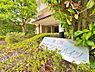 エントランス：青々とした植栽に包まれた品のあるマンション銘板。豊かな緑が居住者や訪れる人をやさしく出迎え、心安らぐアプローチを演出します。