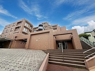 外観：落ち着いた色合いの外観が印象的な建物です。段差の少ないアプローチが特徴です。重厚感のあるつくりが安心感を与えます。階段やスロープで動線も確保されています。周辺の景観に調和した外観です。