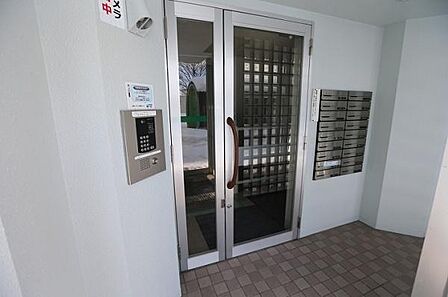 こちらはマンションのエントランスでございます。オートロックを完備しており、セキュリティ面でも安心してお住まいいただけます。