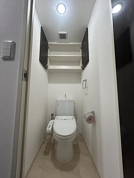 清潔感のあるシンプルなトイレ。温水洗浄便座を備え、上部収納にはトイレットペーパーや掃除用品をすっきり保管可能。生活感を抑えながら、毎日快適に使える機能的な空間です。
