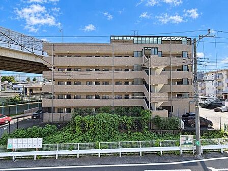 別角度から見たマンション外観。ワイドな建物形状と各住戸のバルコニー配置が分かりやすく、建物全体の規模感や落ち着いた雰囲気を確認できる一枚です。