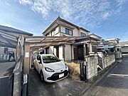 広々とした駐車スペースが特徴的な外観です。落ち着いた色合いの建物は穏やかな街並みに溶け込んでいます。屋根の形状が魅力を引き立て住まいに安定感を与えています。